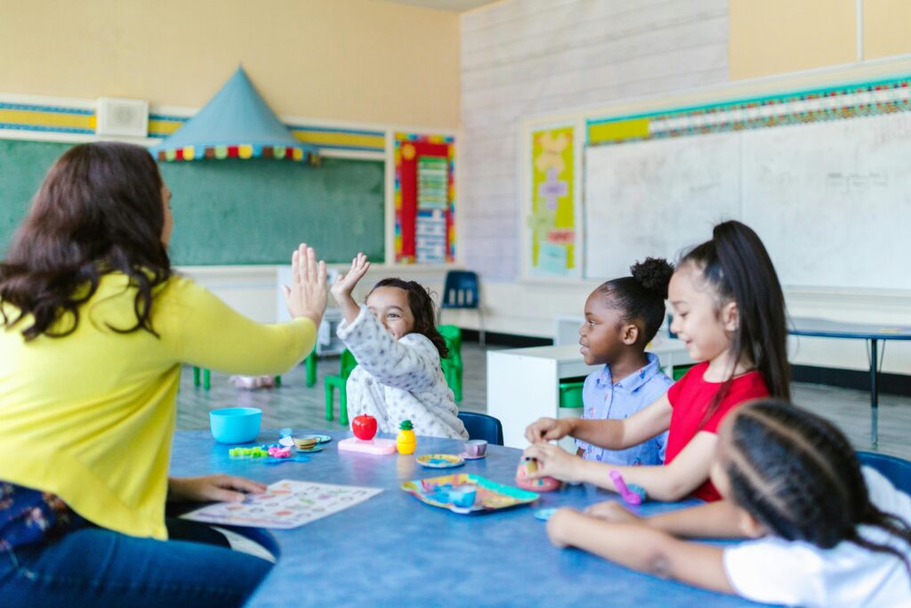 A joyful classroom scene with a teacher and diverse group of children engaging in playful learning activities.